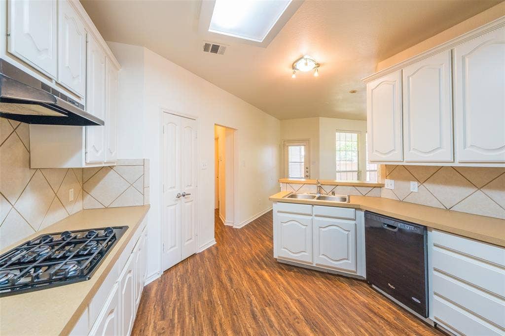 Kitchen featuring white cabinetry, wood-finish flooring, diamond-pattern tile backsplash, built-in gas cooktop, and a double-basin stainless steel sink
