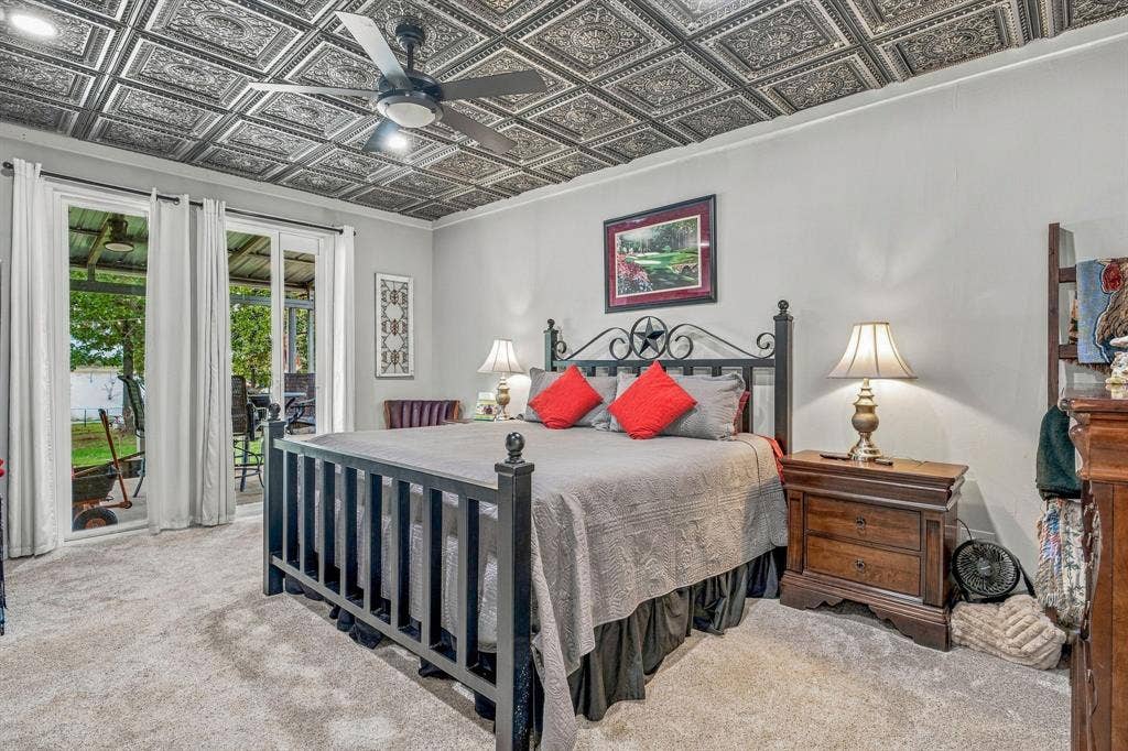 1579 Eastside Lake Road, Graham, TX 76450 Ornate coffered ceiling with detailed pressed-tin panels, recessed lighting, and a central ceiling fan. Sliding glass door open to covered back porch.