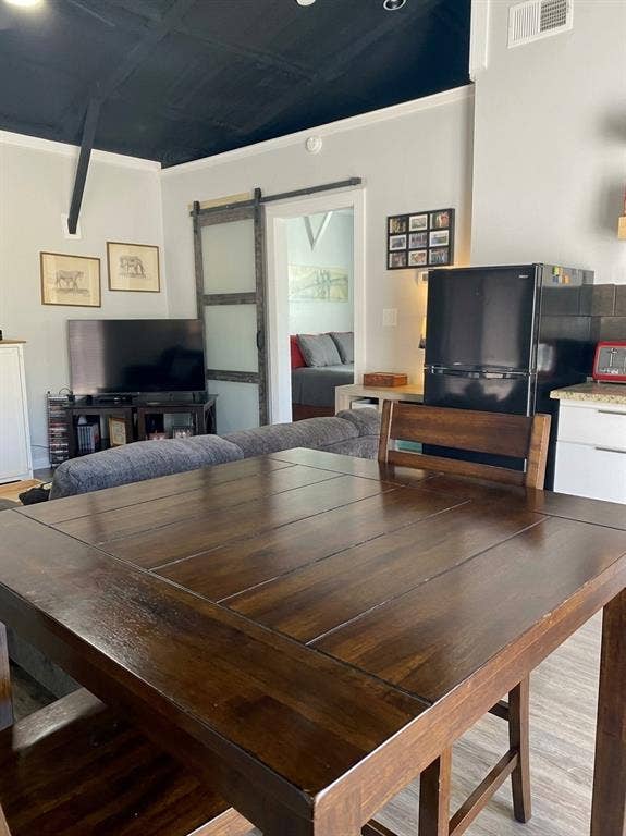 1579 Eastside Lake Road, Graham, TX 76450 Dark-toned vaulted ceiling, sliding barn door with frosted glass panel, and light-toned wood-finish flooring