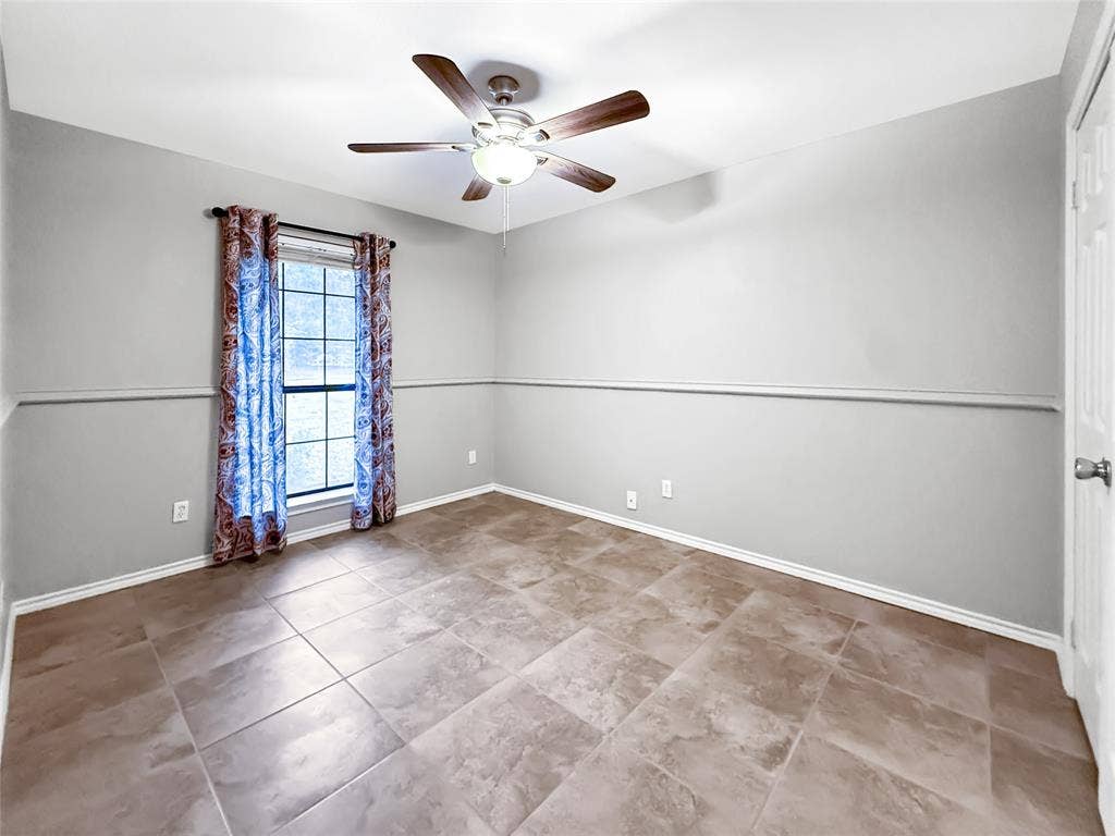305 N Cottonbelt Avenue, Wylie, TX 75098 Room featuring large-format ceramic tile flooring, neutral wall paint, a chair rail, and a ceiling fan with integrated lighting