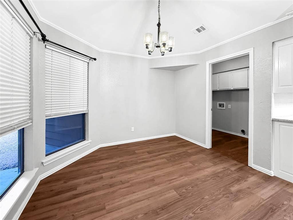 305 N Cottonbelt Avenue, Wylie, TX 75098 Bay area with multi-pane windows, wood-finish flooring, vaulted ceiling, and an architectural hanging chandelier