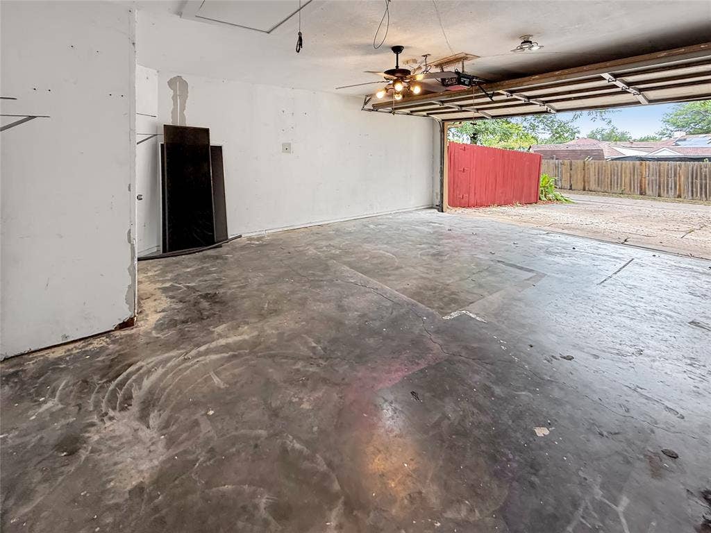 305 N Cottonbelt Avenue, Wylie, TX 75098 Garage space featuring a concrete floor, ceiling-mounted light fixture, and an automated overhead garage door