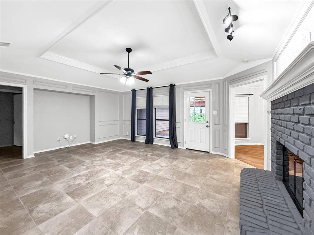 305 N Cottonbelt Avenue, Wylie, TX 75098 Tray ceiling with molding, tile flooring, painted brick fireplace, and built-in wall paneling