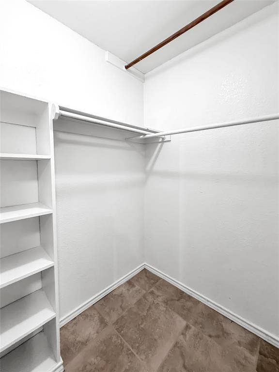 305 N Cottonbelt Avenue, Wylie, TX 75098 Storage space featuring built-in white shelving, integrated hanging rods, and tile flooring