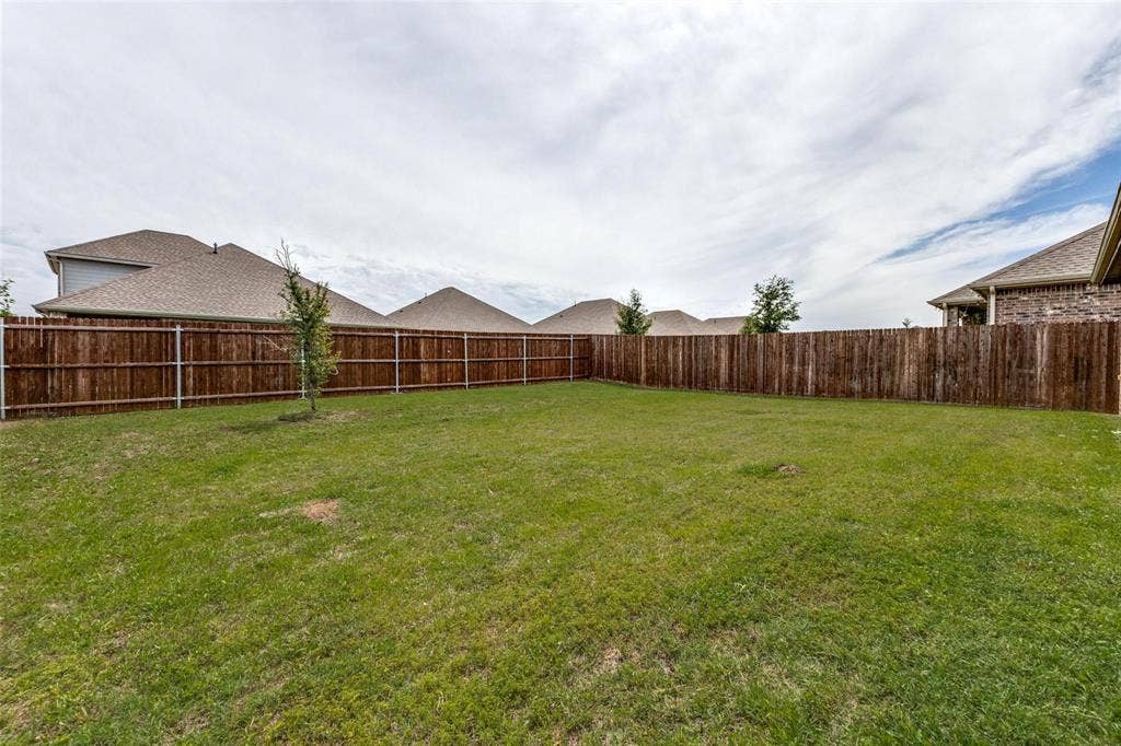 Expansive backyard featuring a level lawn and a full-perimeter stained wood privacy fence
