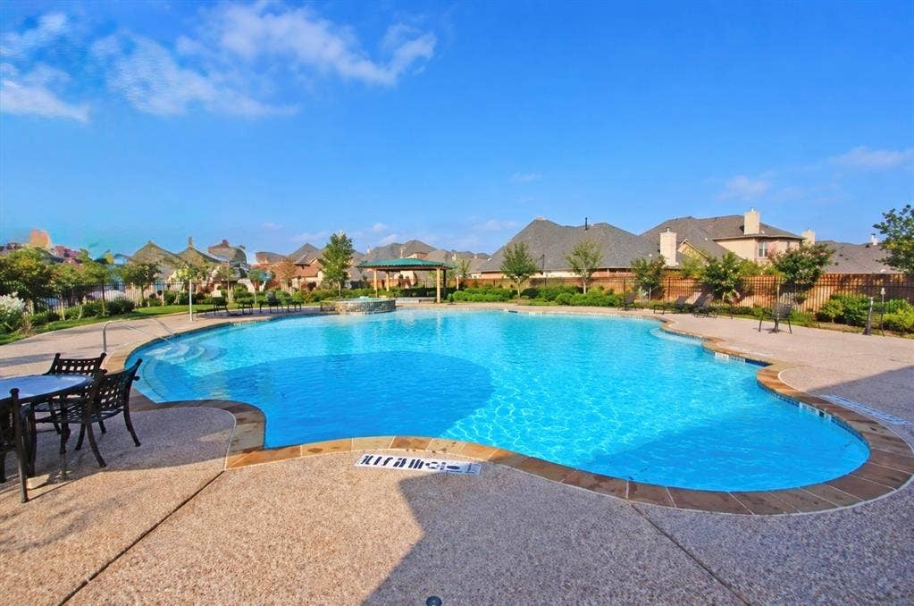 8616 Naomi Street, Plano, TX 75024 Swimming pool with stone-texture decking, integrated spa, and covered pergola