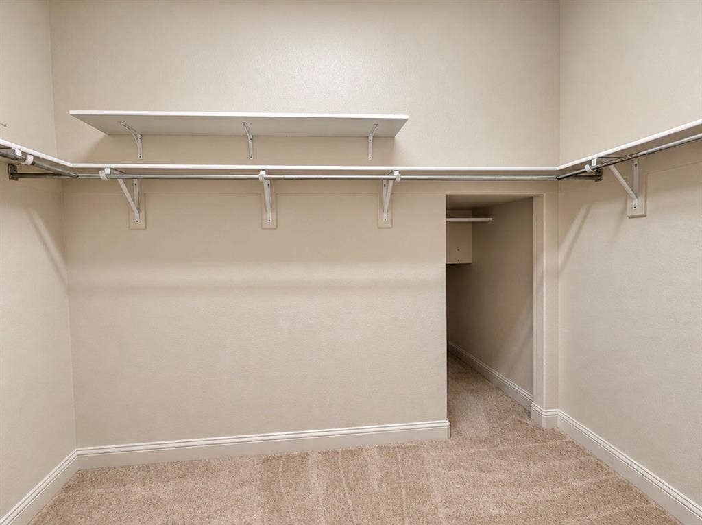 8616 Naomi Street, Plano, TX 75024 Walk-in closet featuring wall-to-wall carpeting, tiered shelving, metal hanging rods, and a supplemental storage nook