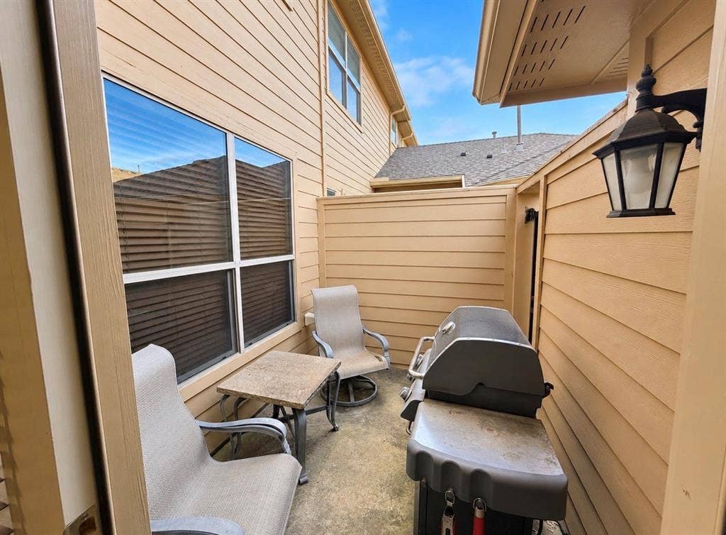 8616 Naomi Street, Plano, TX 75024 Private concrete patio featuring horizontal lap siding, a fenced enclosure, and an attached exterior wall-mounted lantern light