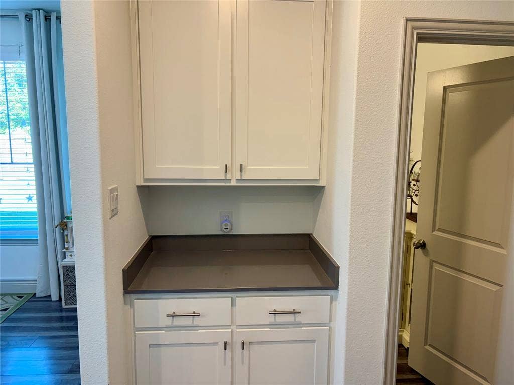 9096 Phoebe Road, Frisco, TX 75035 Built-in cabinetry featuring white shaker-style doors, matte hardware, and a solid-surface countertop with a matching backsplash