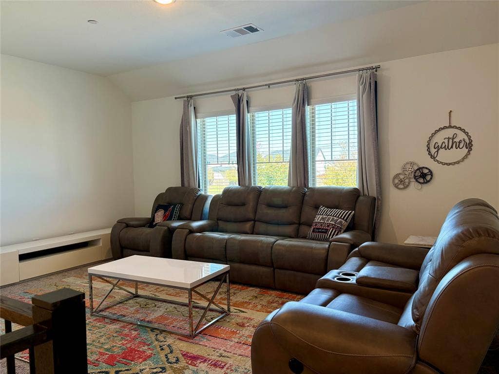 9096 Phoebe Road, Frisco, TX 75035 Vaulted ceiling room featuring a triple-window configuration with horizontal blinds and a built-in low-profile media console