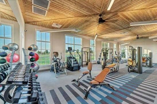 9096 Phoebe Road, Frisco, TX 75035 Vaulted wood-plank ceiling featuring integrated linear lighting and ceiling fans, complemented by expansive multi-pane windows