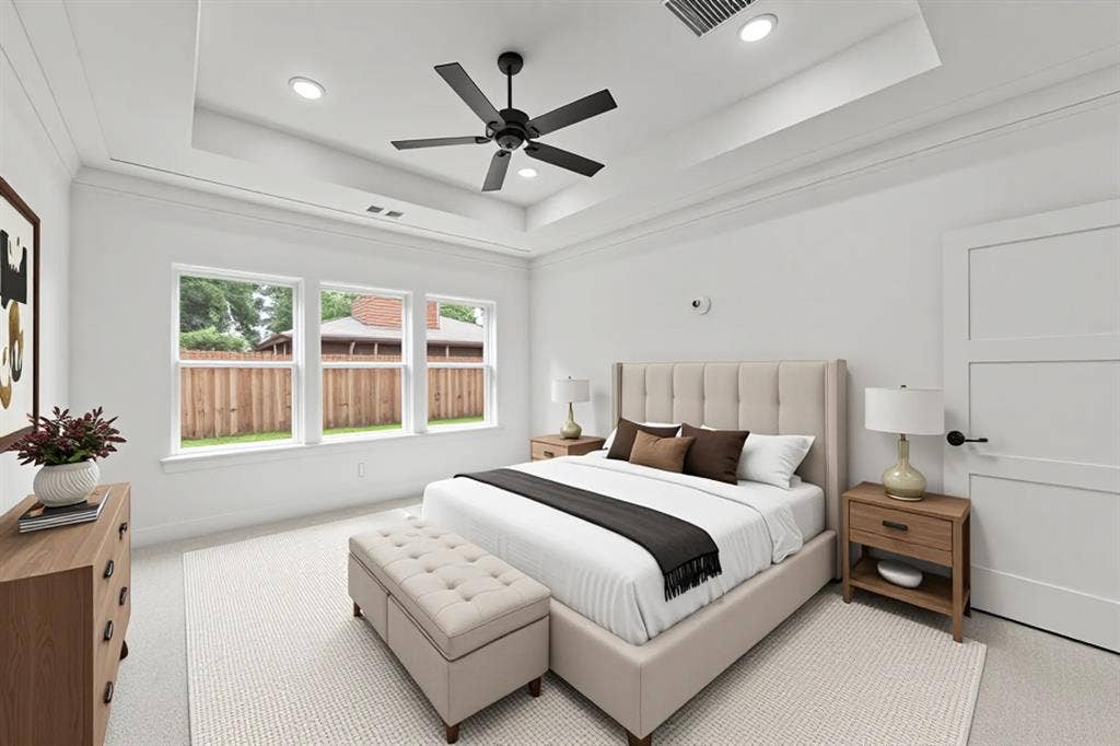 Bedroom with a tray ceiling, light colored carpet, recessed lighting, and ceiling fan