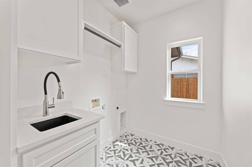 Laundry room with hookup for an electric dryer, hookup for a washing machine, baseboards, a sink, and cabinet space