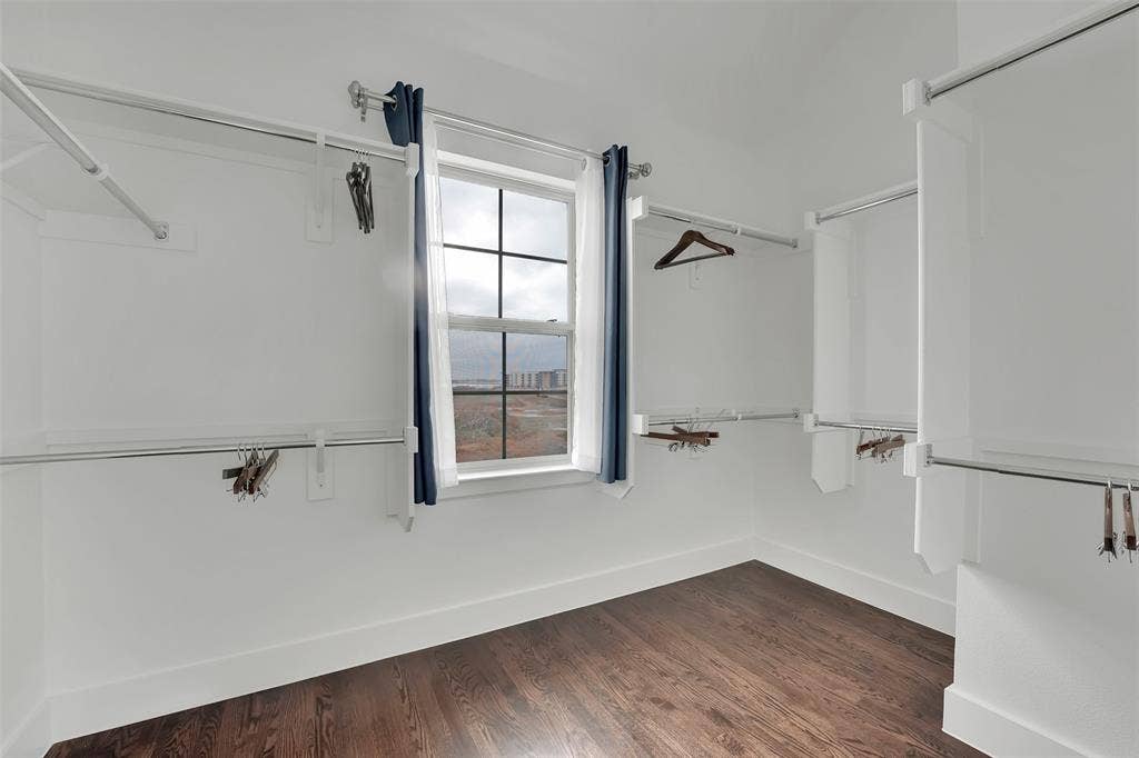 Walk in closet featuring dark wood finished floors
