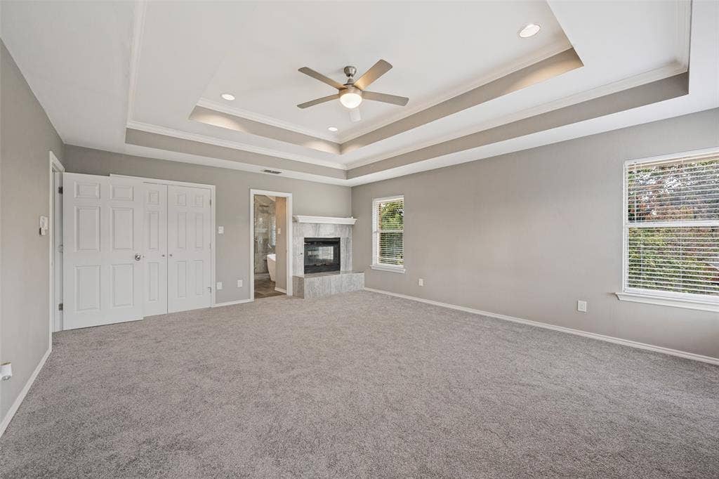 There is ample area near the fireplace for a sitting area in this primary bedroom.