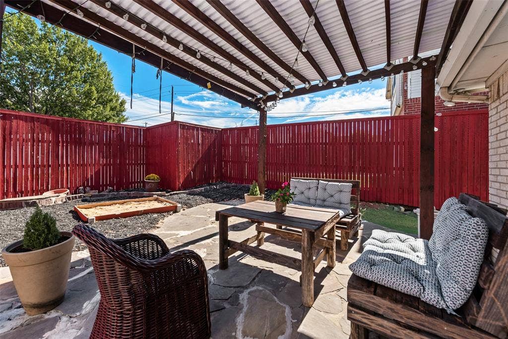 4104 Creekmeadow Drive, Carrollton, TX 75010 Outdoor living space featuring a flagstone patio, wood-framed pergola, and privacy fencing