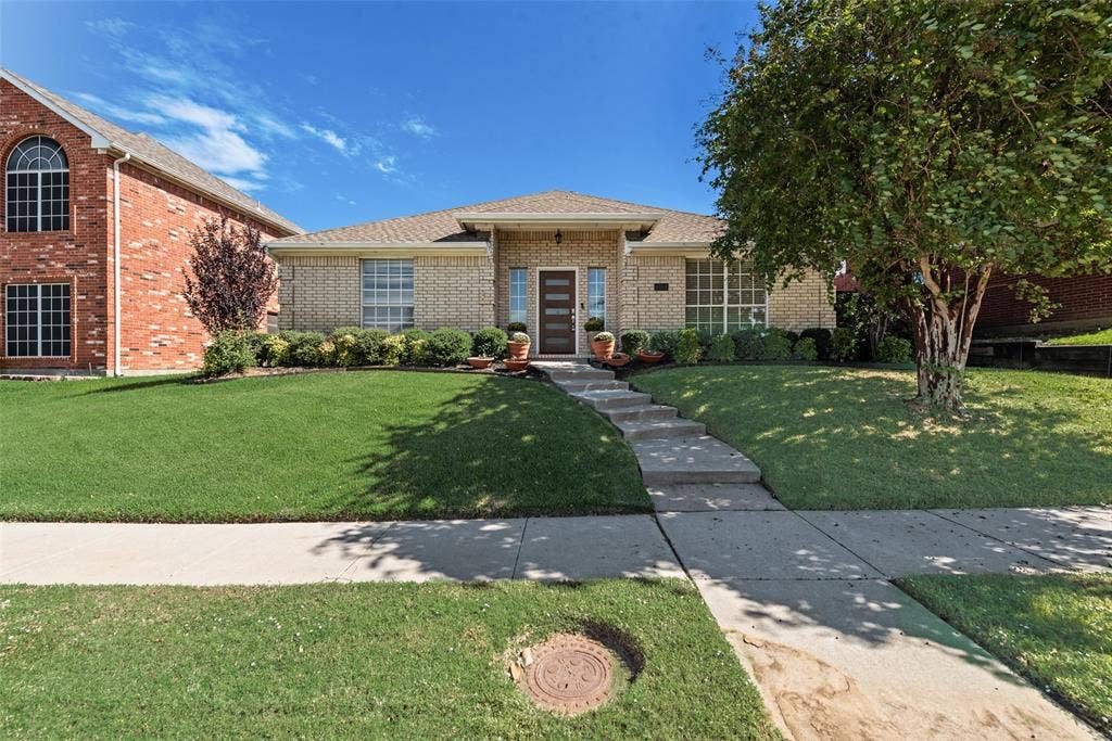 4104 Creekmeadow Drive, Carrollton, TX 75010 Single-story brick exterior featuring a covered front entry, multi-pane windows, and a concrete walkway