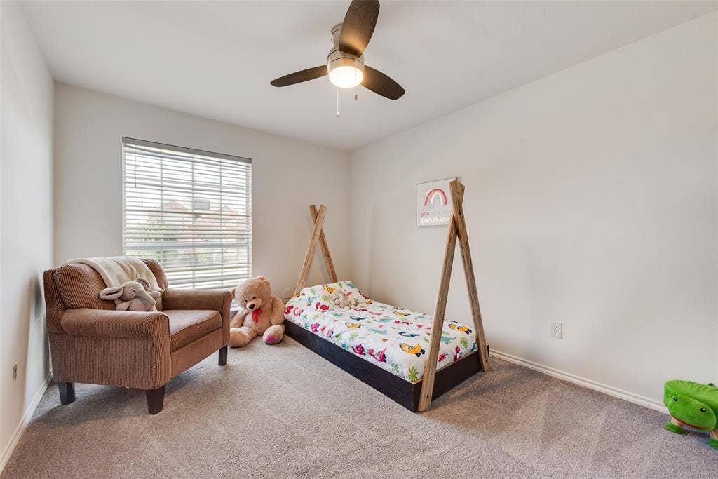 4104 Creekmeadow Drive, Carrollton, TX 75010 Neutral-toned wall-to-wall carpeting, window with integrated horizontal blinds, and a three-blade ceiling fan with a center light fixture