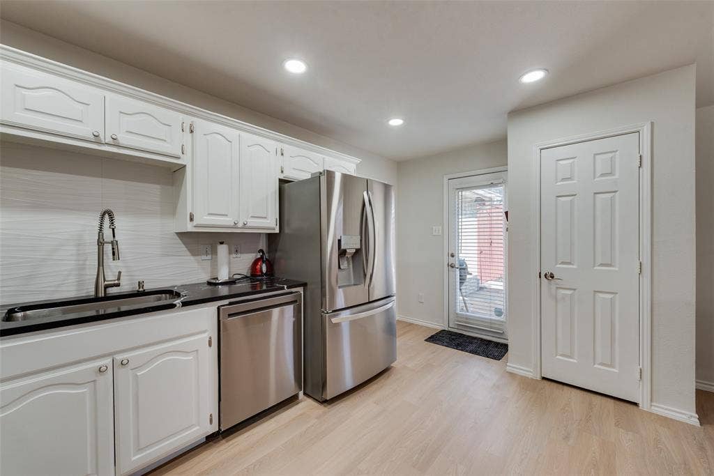 4104 Creekmeadow Drive, Carrollton, TX 75010 Kitchen featuring white cabinetry, dark countertops, stainless steel appliances, wood-finish flooring, and recessed lighting