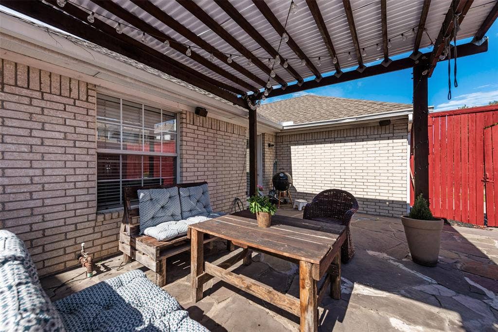 4104 Creekmeadow Drive, Carrollton, TX 75010 Covered patio featuring a wood pergola, brick exterior siding, and flagstone paving