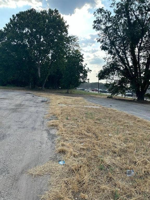 3110 W Gentry Parkway, Tyler, TX 75702 Expansive lot featuring mature trees and paved surface areas