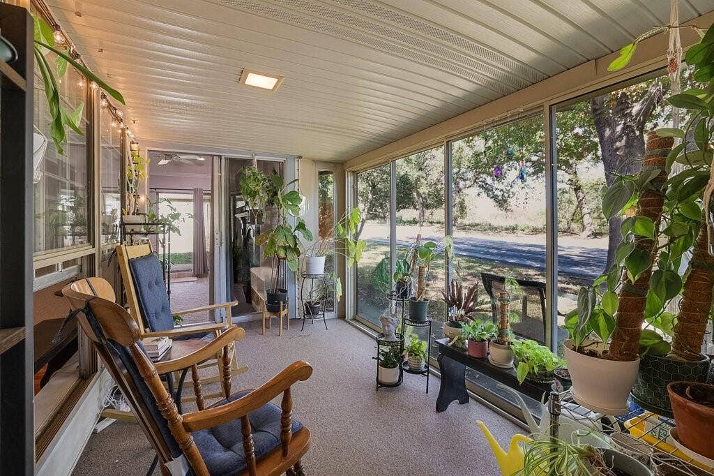 Enclosed sunroom featuring expansive floor-to-ceiling screens, a corrugated ceiling, and wall-to-wall carpeting