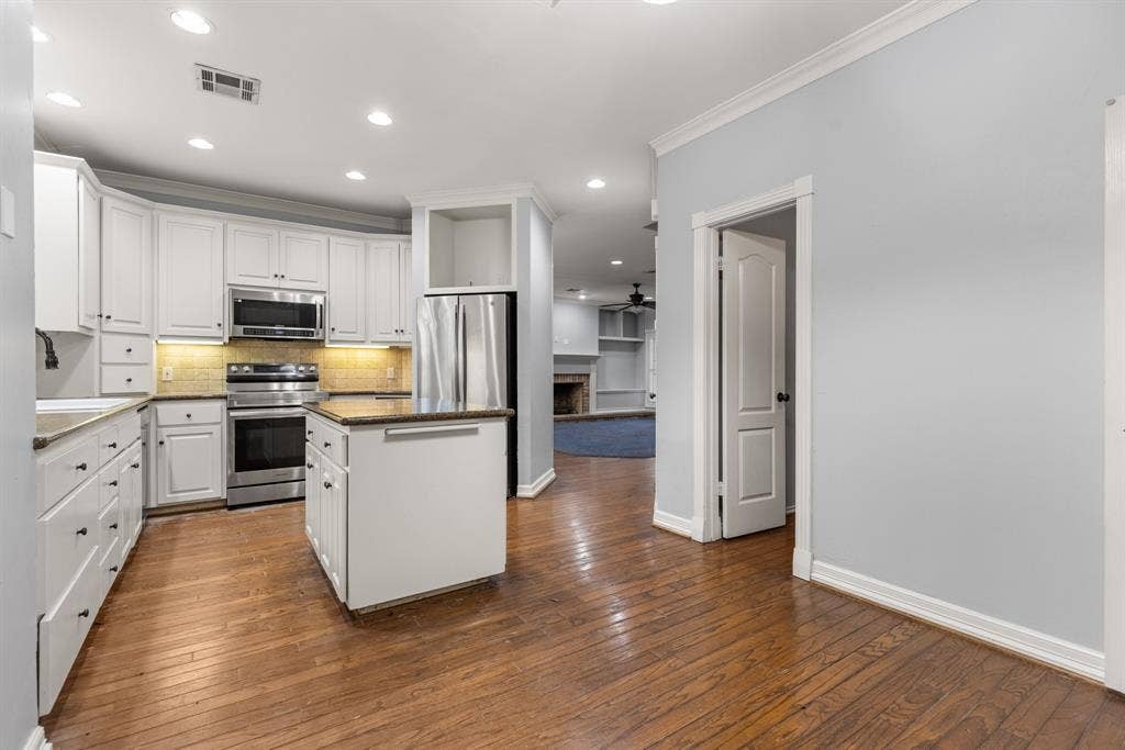 207 Westlane Circle, Woodway, TX 76712 Kitchen featuring white cabinetry, wood-finish flooring, a central island, recessed lighting, and stainless steel appliances