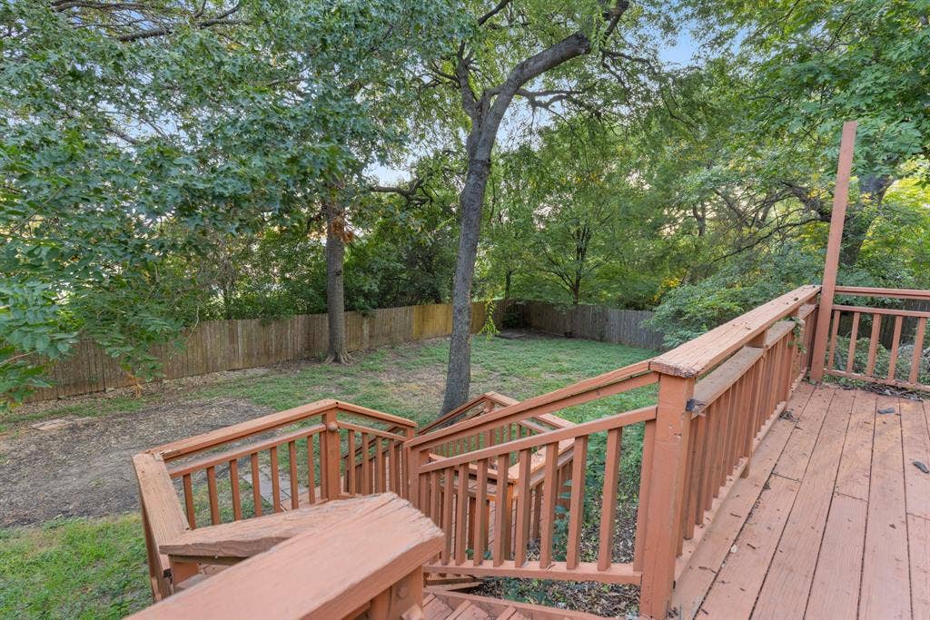 207 Westlane Circle, Woodway, TX 76712 Elevated wood deck with balustrade railings, wooden staircase, mature trees, and privacy fencing