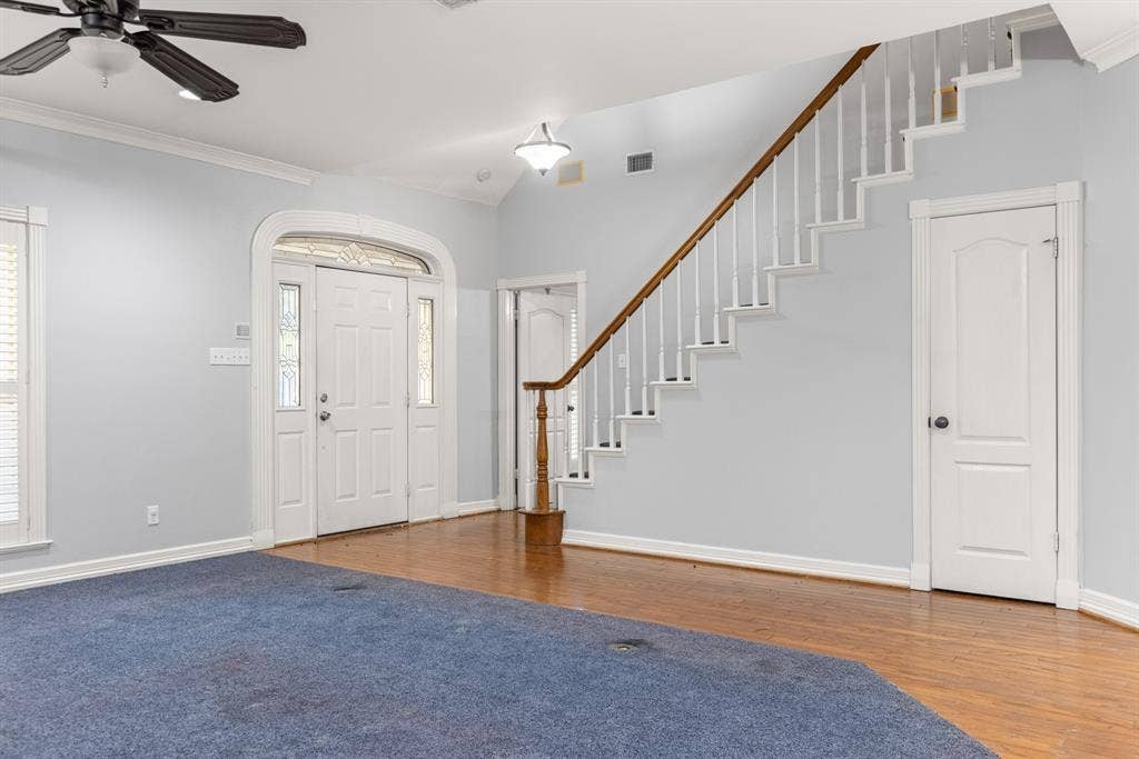 207 Westlane Circle, Woodway, TX 76712 Foyer featuring wood-finish flooring, a staircase with a wooden handrail, and an arched entry door with side windows and a transom
