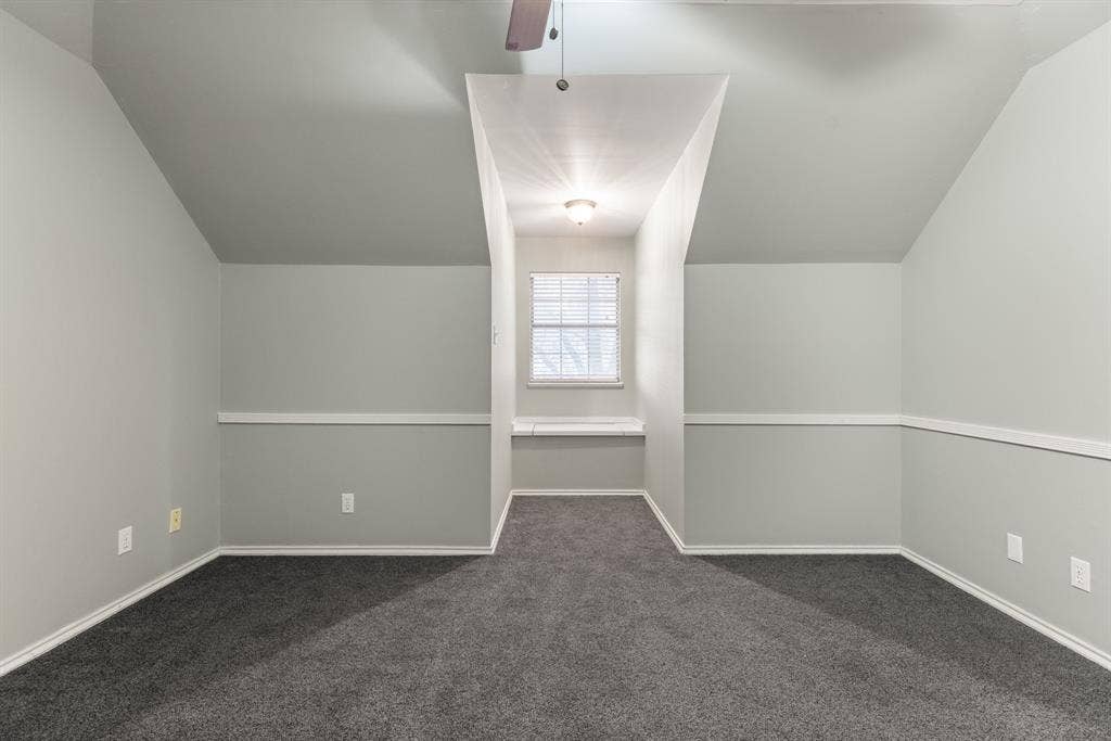 207 Westlane Circle, Woodway, TX 76712 Vaulted ceilings with a ceiling fan, neutral wall paint, chair rail molding, carpeted flooring, and a built-in window seat