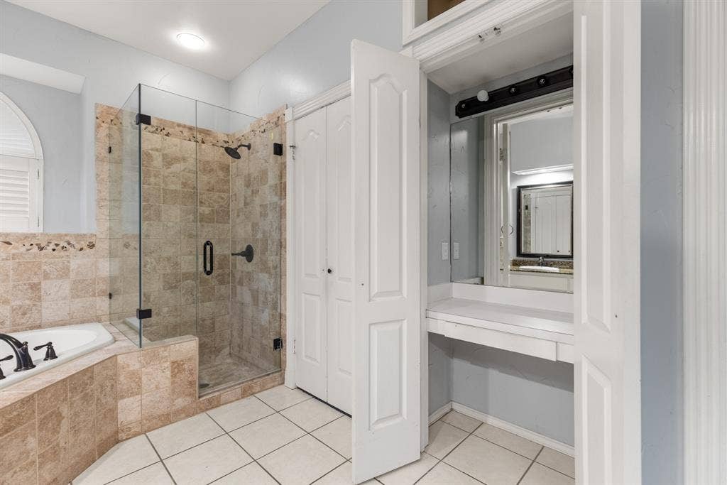 207 Westlane Circle, Woodway, TX 76712 Bathroom featuring a tiled shower with a glass enclosure, an integrated soaking tub, built-in vanity, and ceramic tile flooring