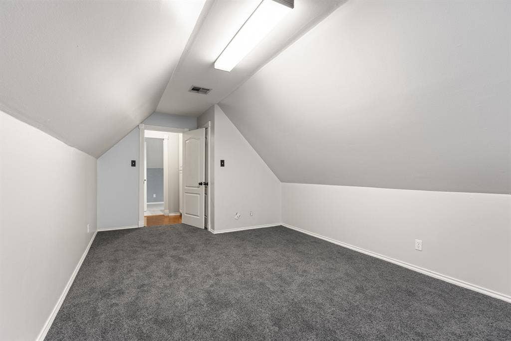 207 Westlane Circle, Woodway, TX 76712 Sloped ceiling architecture featuring recessed wall angles, wall-to-wall carpeting, and a central linear light fixture
