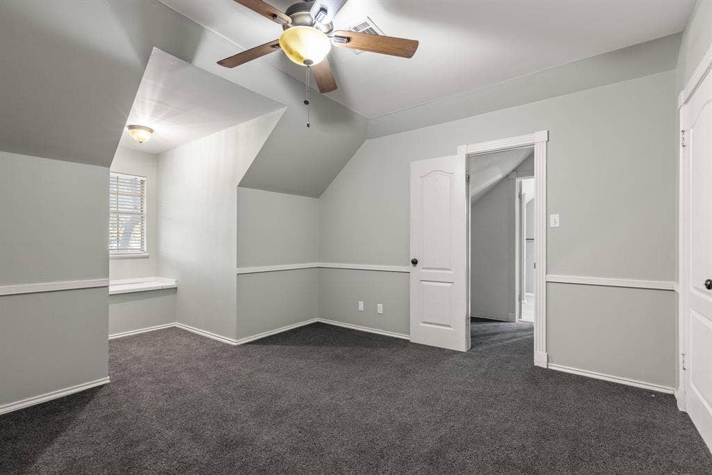 207 Westlane Circle, Woodway, TX 76712 Room featuring vaulted ceilings, carpeted flooring, chair rail molding, built-in window seating, and a multi-blade ceiling fan with integrated lighting