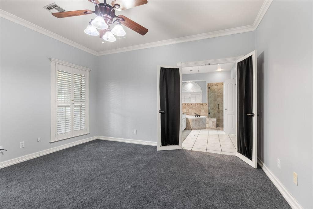 207 Westlane Circle, Woodway, TX 76712 Carpeted room featuring white crown molding, shuttered windows, and a multi-light ceiling fan