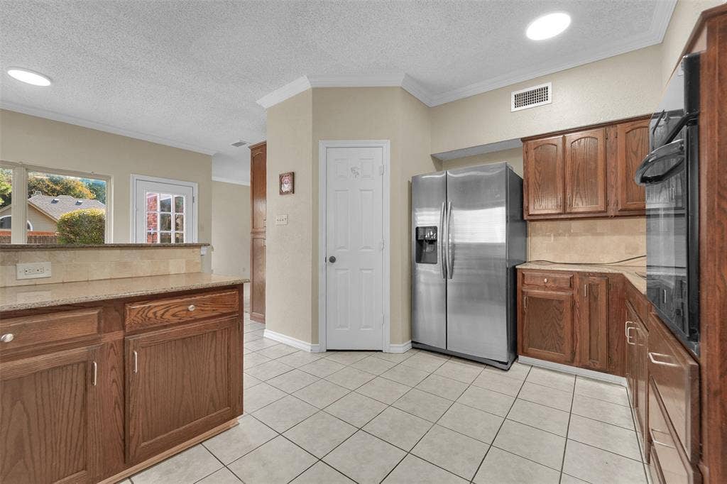 1920 Keystone Drive, Plano, TX 75075 Kitchen featuring wood cabinetry, stone countertops, tiled backsplash, stainless steel refrigerator, and built-in wall oven