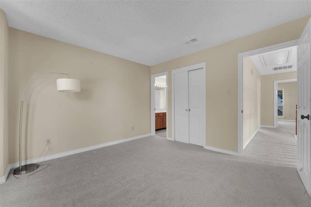 1920 Keystone Drive, Plano, TX 75075 Neutral-toned bedroom featuring wall-to-wall carpeting, textured ceiling, and a dual-panel closet door