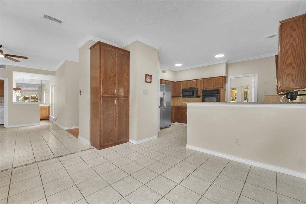 1920 Keystone Drive, Plano, TX 75075 Kitchen featuring wood cabinetry, stainless steel appliances, neutral tile flooring, recessed lighting, and a peninsula countertop