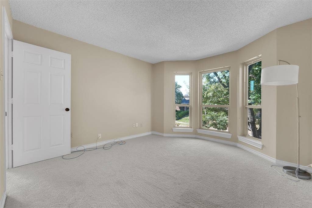1920 Keystone Drive, Plano, TX 75075 Interior space featuring neutral wall tones, wall-to-wall carpeting, and a bay window assembly