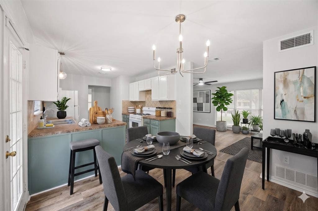1605 Proctor Drive, Grand Prairie, TX 75051 AI IMAGINED - Open-concept living space featuring wood-finish flooring and a contemporary chandelier