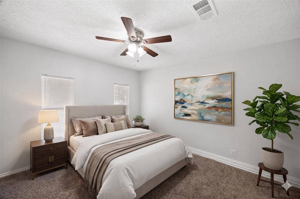 1605 Proctor Drive, Grand Prairie, TX 75051 AI IMAGINED - Carpeted bedroom featuring a ceiling fan with light fixture, two windows with blinds, and white baseboards