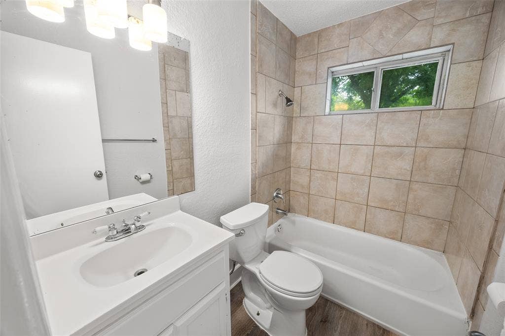 1605 Proctor Drive, Grand Prairie, TX 75051 Bathroom featuring a white vanity with integrated sink, chrome faucet, and a large wall mirror