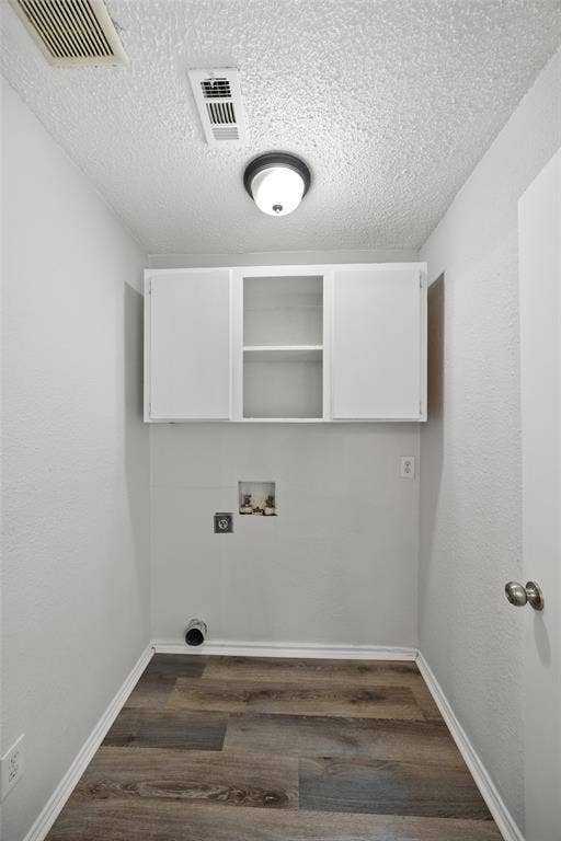 1605 Proctor Drive, Grand Prairie, TX 75051 Dedicated utility space featuring overhead cabinetry and wood-finish flooring