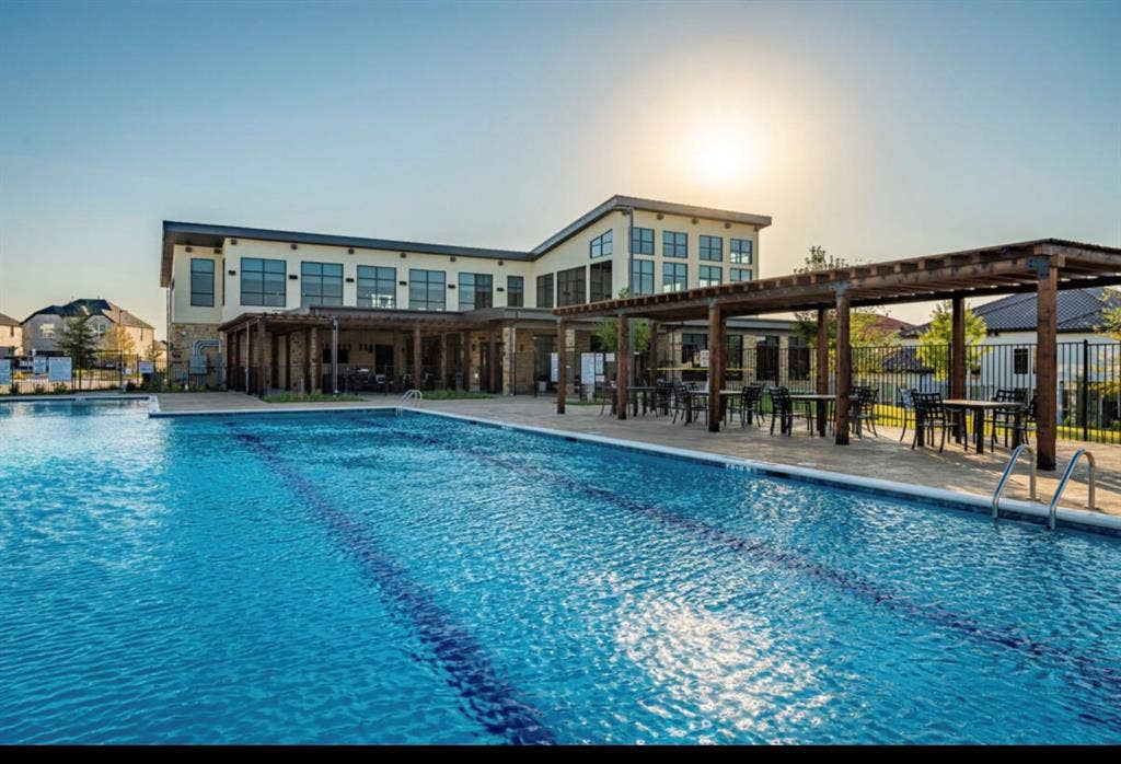 12173 Deer Trail, Frisco, TX 75035 Community pool featuring a multi-lane lap design, stone-paved decking, and a timber-framed pergola structure