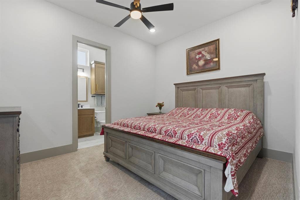 12173 Deer Trail, Frisco, TX 75035 Neutral interior room featuring neutral carpeting, a ceiling fan with integrated lighting, and a doorway opening to a secondary space with a wood-finish vanity and cabinetry