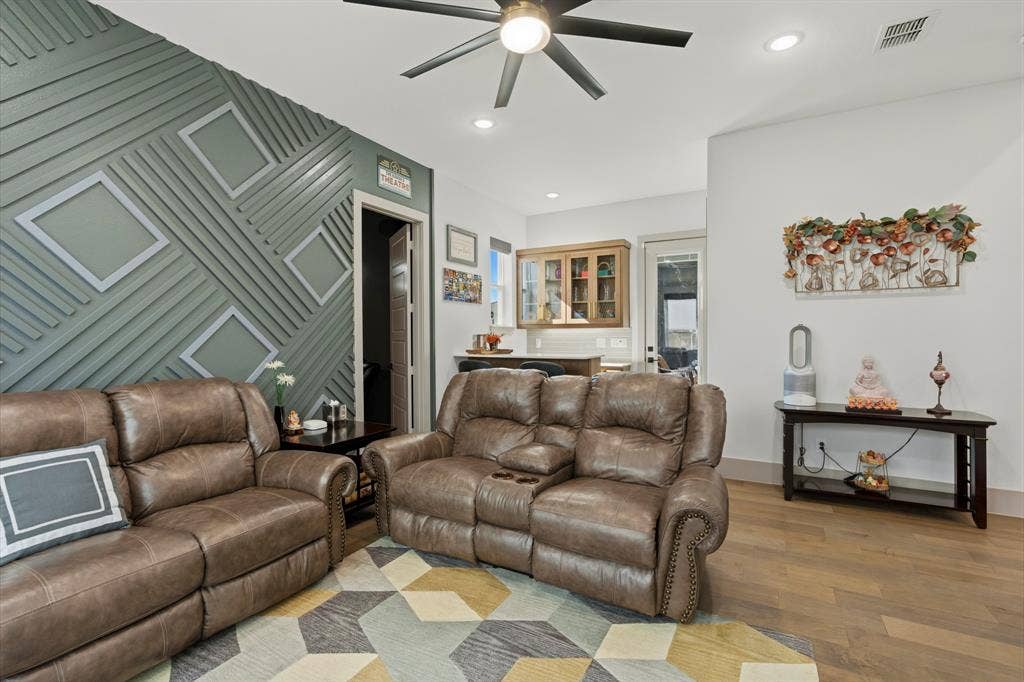 12173 Deer Trail, Frisco, TX 75035 Feature wall with geometric millwork, wood-finish flooring, recessed lighting, ceiling fan with light kit, and built-in glass-front cabinetry