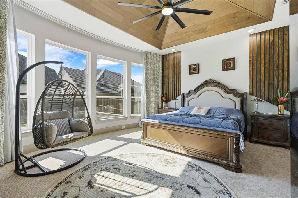 12173 Deer Trail, Frisco, TX 75035 Vaulted wood-plank ceiling featuring a multi-blade ceiling fan, large windows, and decorative vertical wood wall paneling