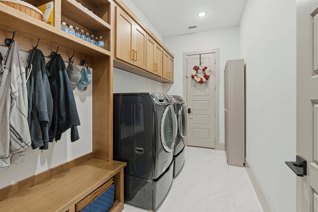 12173 Deer Trail, Frisco, TX 75035 Utility room featuring custom wood cabinetry, integrated mudroom storage with coat hooks, tile flooring, and a solid-core interior door with matte black hardware