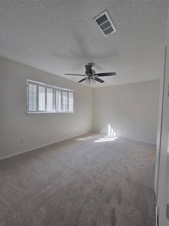Interior room featuring wall-to-wall carpeting, neutral wall coloring, a multi-blade ceiling fan with integrated lighting, and plantation-style window shutters