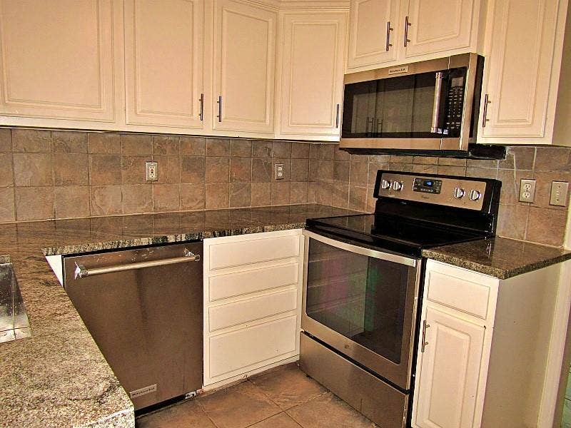 313 Timbercreek Court, Princeton, TX 75407 Kitchen featuring white shaker-style cabinetry, stone countertops, stainless steel appliances, and a tiled backsplash