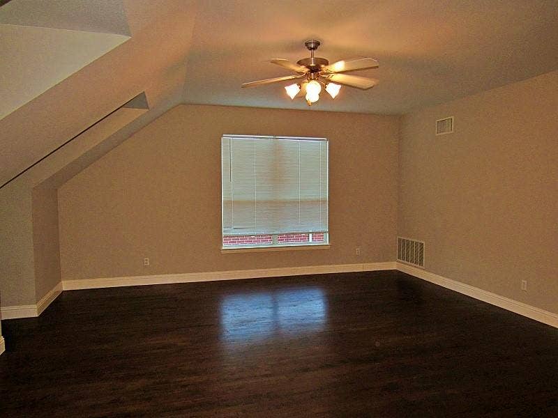 313 Timbercreek Court, Princeton, TX 75407 Vaulted ceiling featuring dark wood-finish flooring, a central ceiling fan with multi-bulb lighting, and a window with integrated blinds